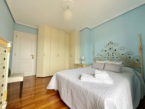 Una camera da letto con un letto, un comodino, una sedia e un armadio.