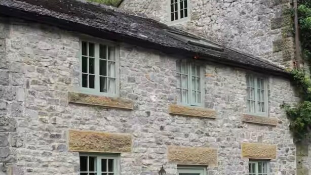 A stone building with multiple windows, a door, and potted plants. - 2 Bed-sleeps 3-dog Friendly-garden-riverside (Buxton)