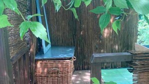 A wicker basket on a wooden floor, a wooden bench, and a wooden railing. - 2 Bed-sleeps 3-dog Friendly-garden-riverside (Buxton)