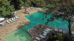 A pool area with lounge chairs, a small slide, and a surrounding deck.