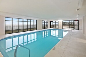 A large indoor swimming pool with clear views of a bridge and cityscape through large windows. - Grand Pointe 313- gulf front, 3 bedrooms, 3.5 baths, 3rd floor, HUGE balcony (Orange Beach)