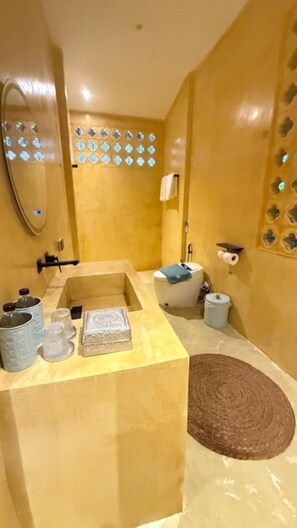 A bathroom with a bathtub, a toilet, and a sink. There are decorative tiles on the walls and a mirror above the sink. - Cape Beach Villa Koh Samui (Koh Samui)