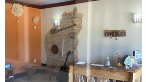A reception area with a wooden desk, a stone wall, and a hanging net.