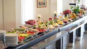 Ein reichhaltiges Buffet mit verschiedenen Speisen und Getränken, darunter Salate, Früchte und Erfrischungen.