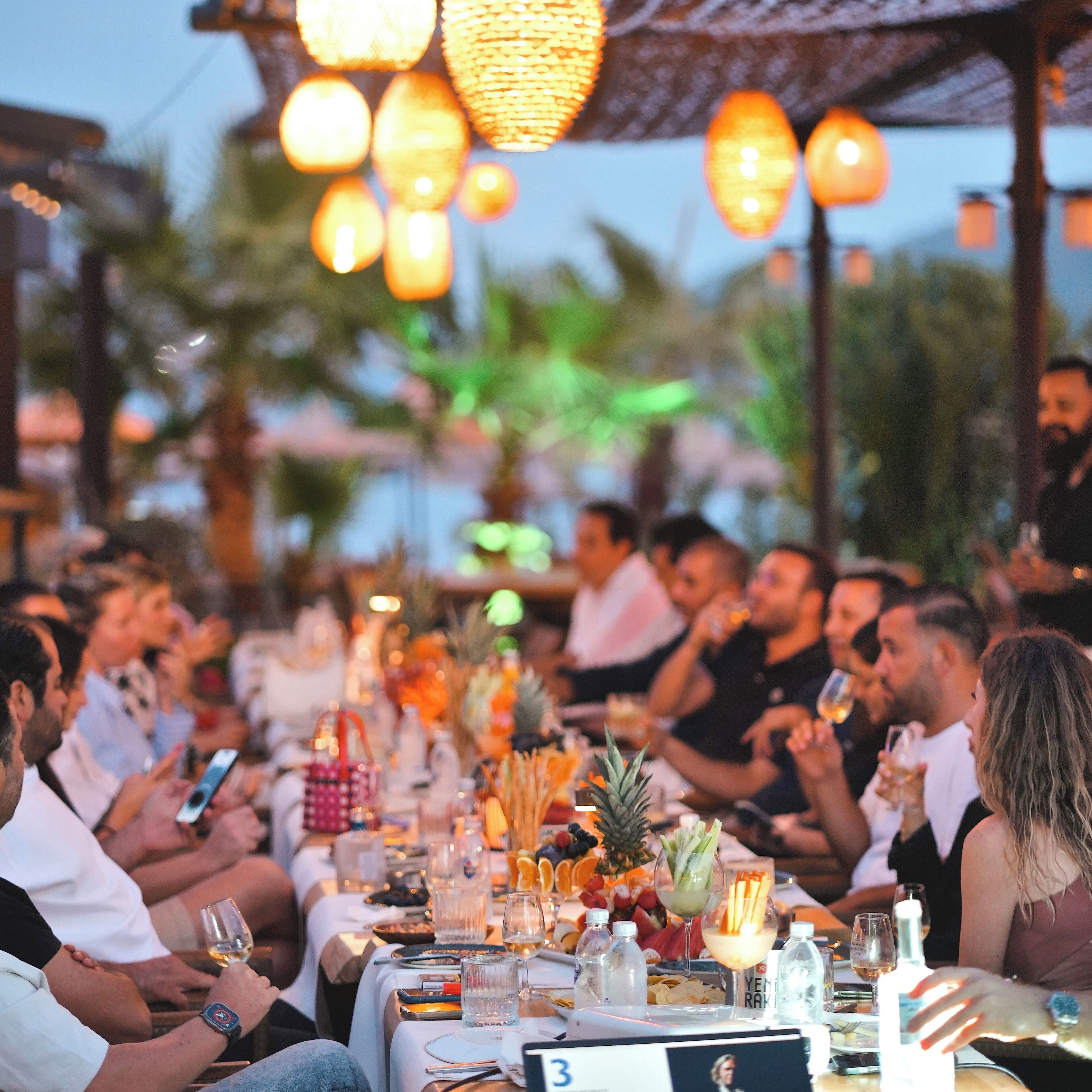 A dining area with tables set for guests, featuring a variety of dishes and drinks.