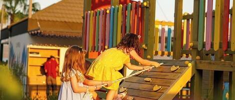 A wooden play structure with a colorful archway and a slide.