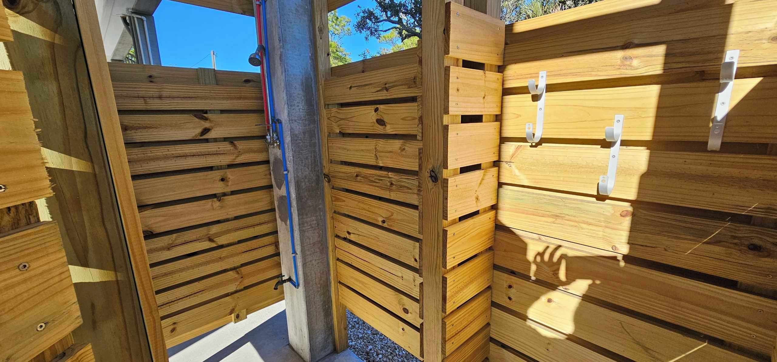 A wooden gate with a metal latch and a metal handle on the right side.