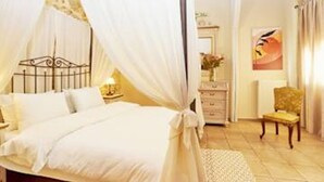 A bedroom with a four-poster bed, a nightstand, a dresser, and a chair.