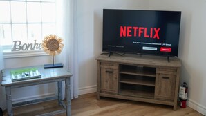 Un televisor sobre un soporte de madera mostrando el logotipo de Netflix.