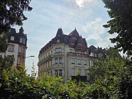 Un hotel histórico con arquitectura ornamentada, varios balcones y un cartel llamativo.