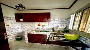 Une cuisine équipée d’une cuisinière, d’un évier et d’une fenêtre ornée de vitraux.
