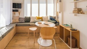 A modern living room with a sofa, a coffee table, and a TV mounted on the wall. - Nice duplex in Saint-Quay, a short walk to the bea (Saint-Quay-Portrieux)