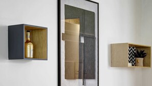 A room with a wooden bench, a framed abstract painting, and two shelves with decorative items. - Spacious 4BDR in Buttes Chaumont pour 12 pers (Paris)