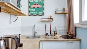 Eine moderne Küche mit Holztischplatte, Spüle, Toaster und einer Wandablage mit Dekoration.