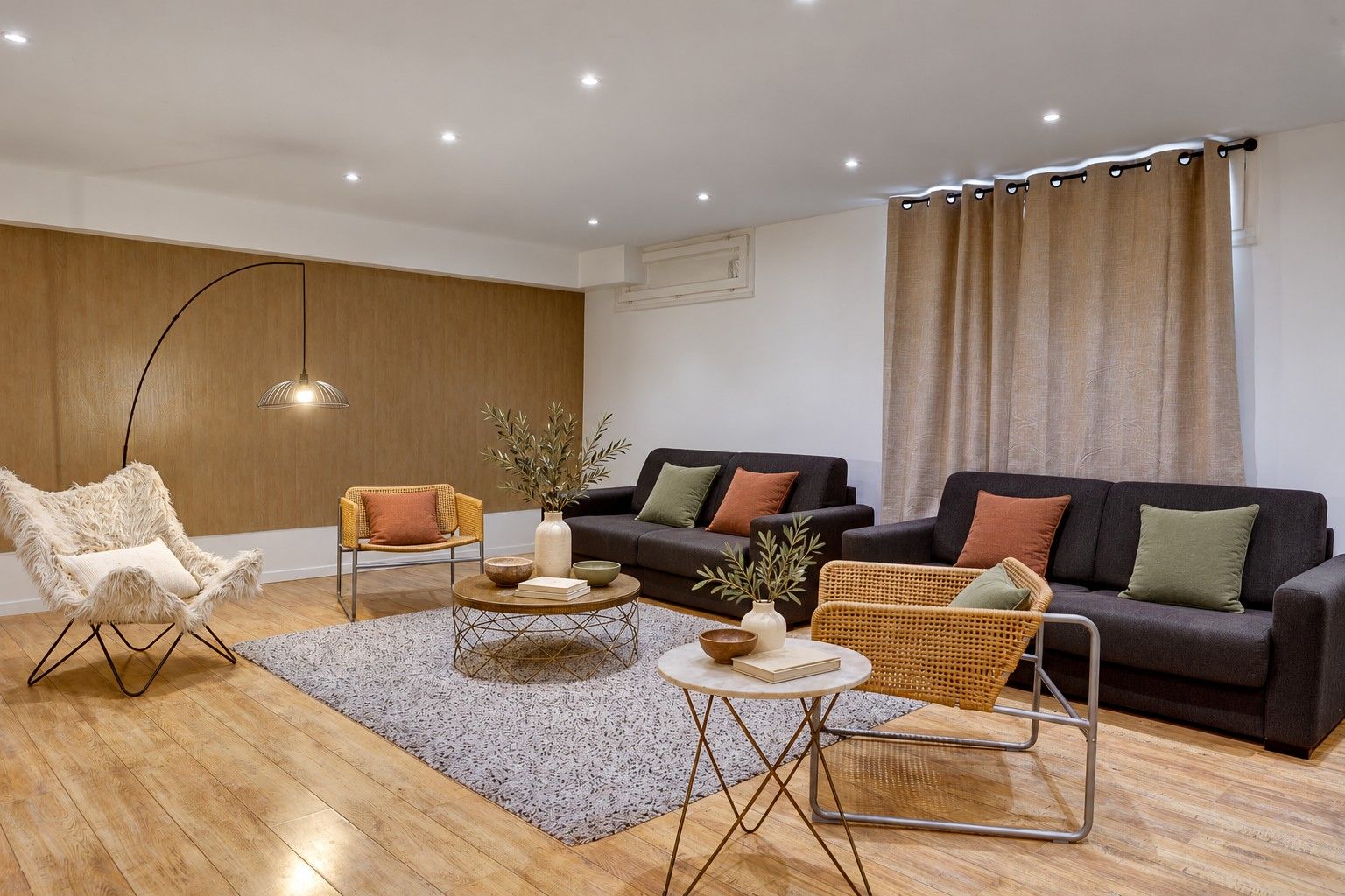 Una sala de estar moderna con un sofá, sillones, una mesa de centro y una lámpara de pie.