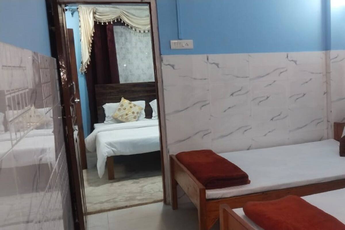 A hotel room with two beds, a wooden headboard, and a marble-patterned wall.