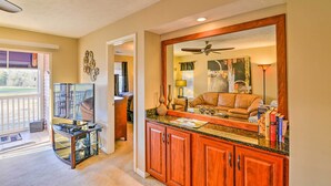 A well-lit living area with a TV, wooden cabinets, and a cozy seating arrangement.
