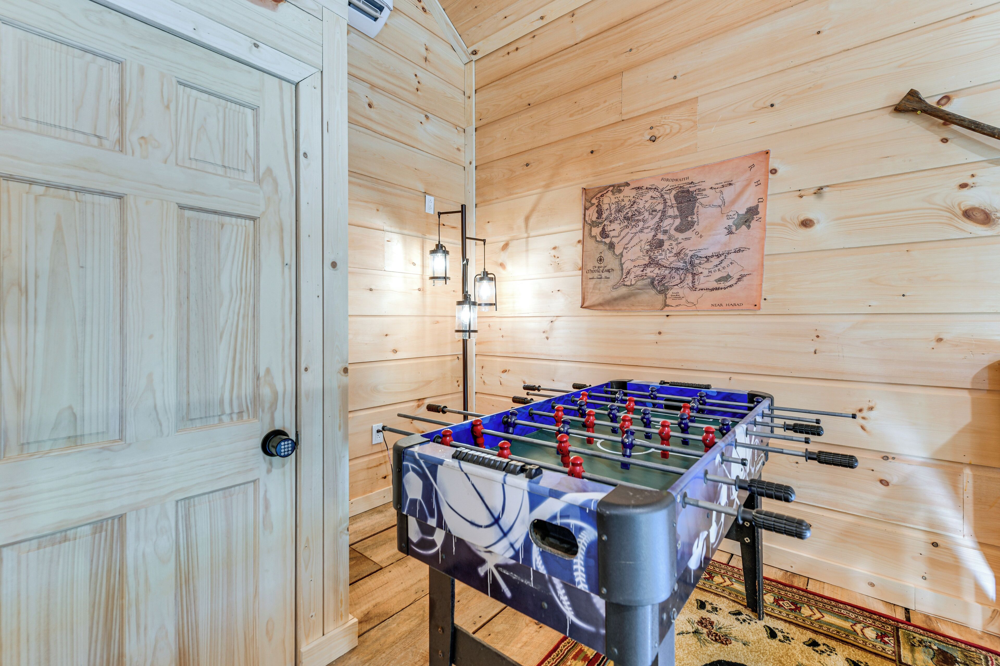 Ein Zimmer mit Holzboden, einer Tischfußballplatte und einer Karte an der Wand.