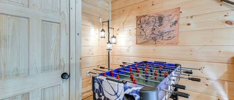 Ein Zimmer mit Holzboden, einer Tischfußballplatte und einer Karte an der Wand.