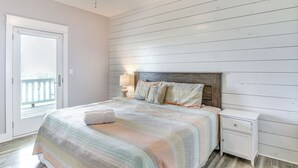 A bedroom with a bed, a nightstand, a lamp, and a view through a door. - 1 Block to Shore: Crystal Beach Gem, Deck & Views (Port Bolivar)