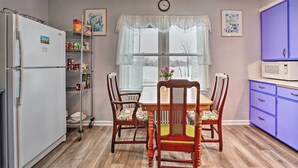 A kitchen with a refrigerator, microwave, and wooden dining table with chairs. - Cozy Cedarburg House - Walk to Historic Downtown! (Cedarburg)