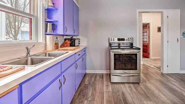 A kitchen with a stainless steel stove, a double sink, and purple cabinets. - Cozy Cedarburg House - Walk to Historic Downtown! (Cedarburg)