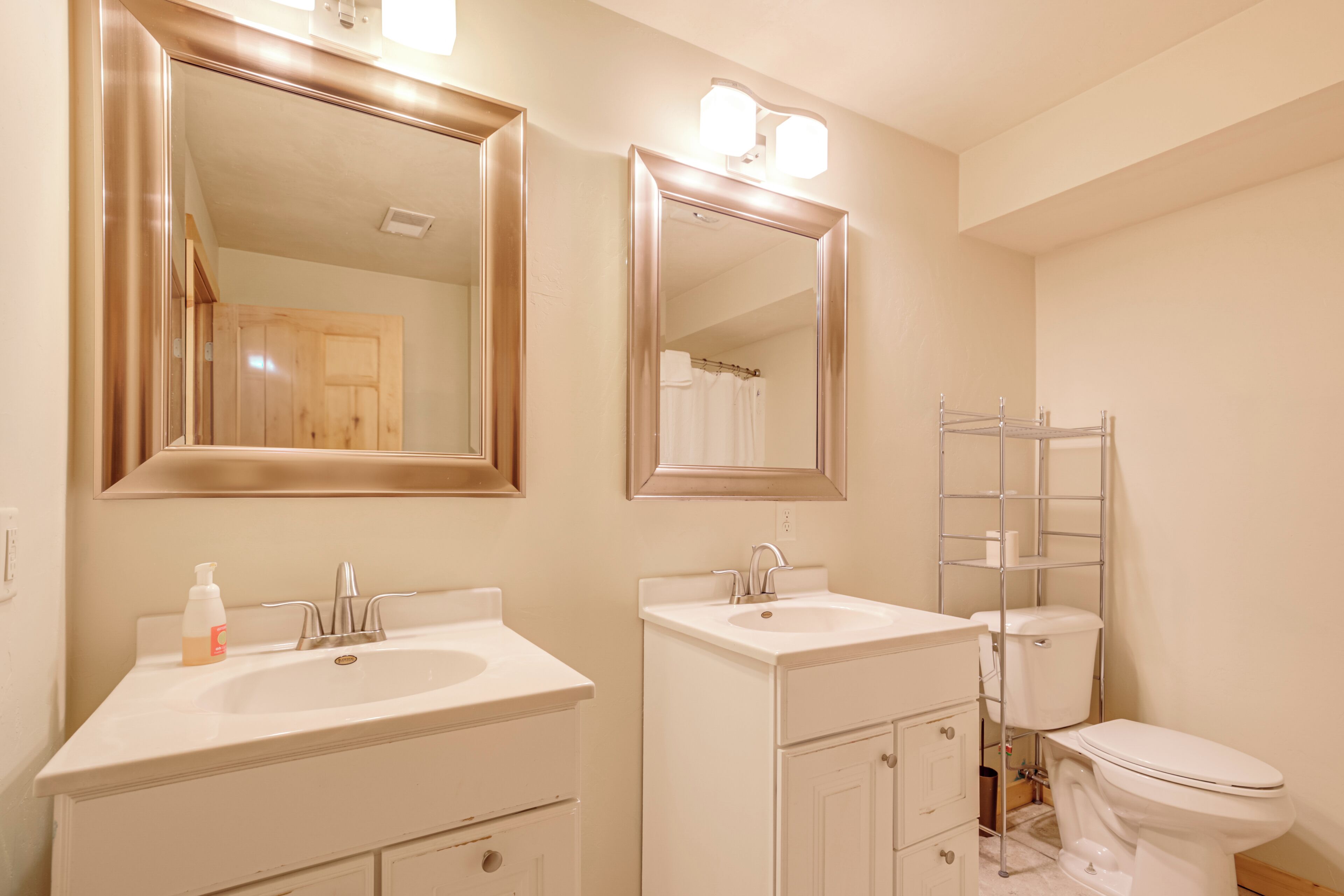 Une salle de bain avec deux lavabos, des toilettes et un espace douche.