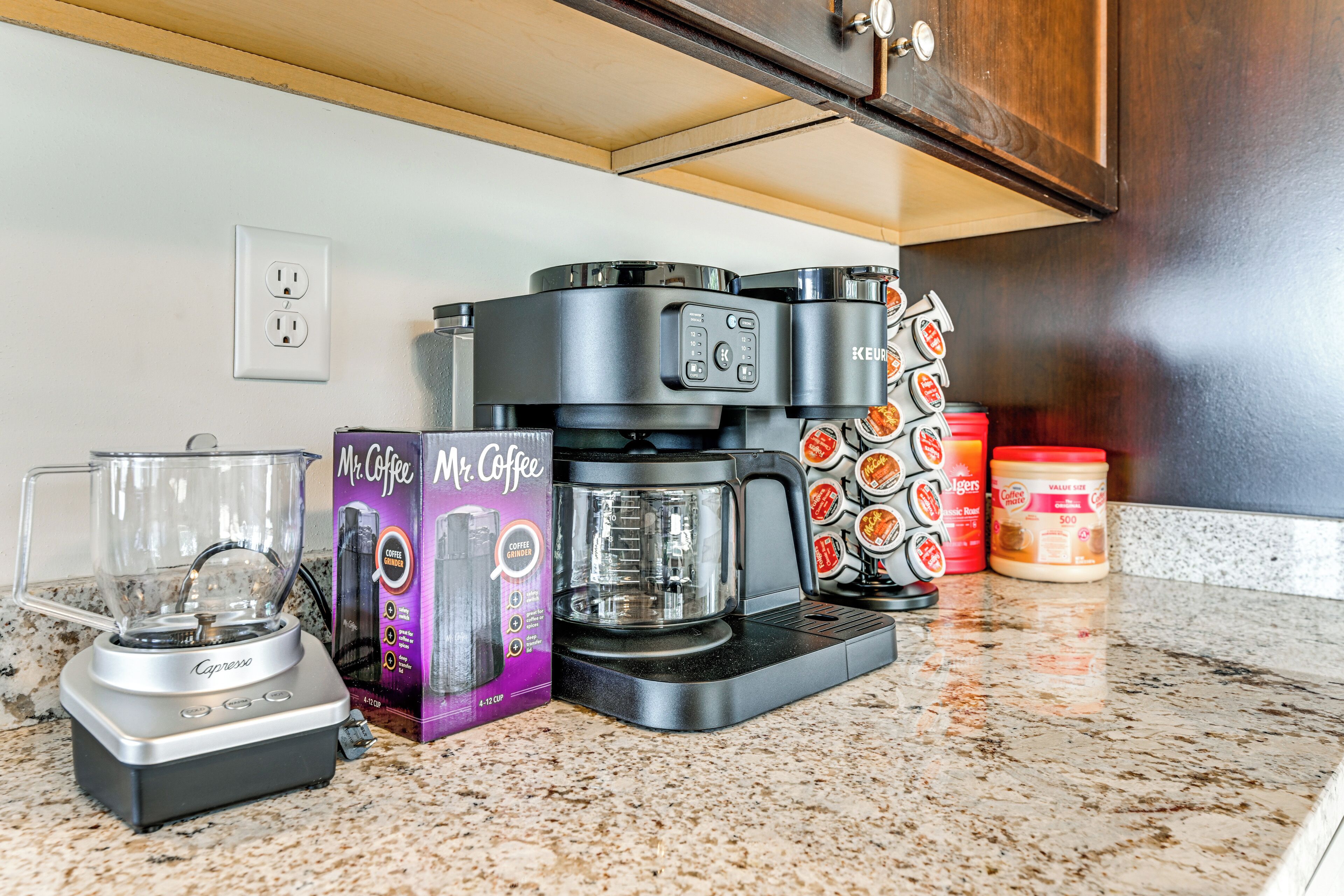 A kitchen with a coffee maker, a Mr. Coffee box, a Mr. Coffee mug, and a Mr. Coffee coffee pot.