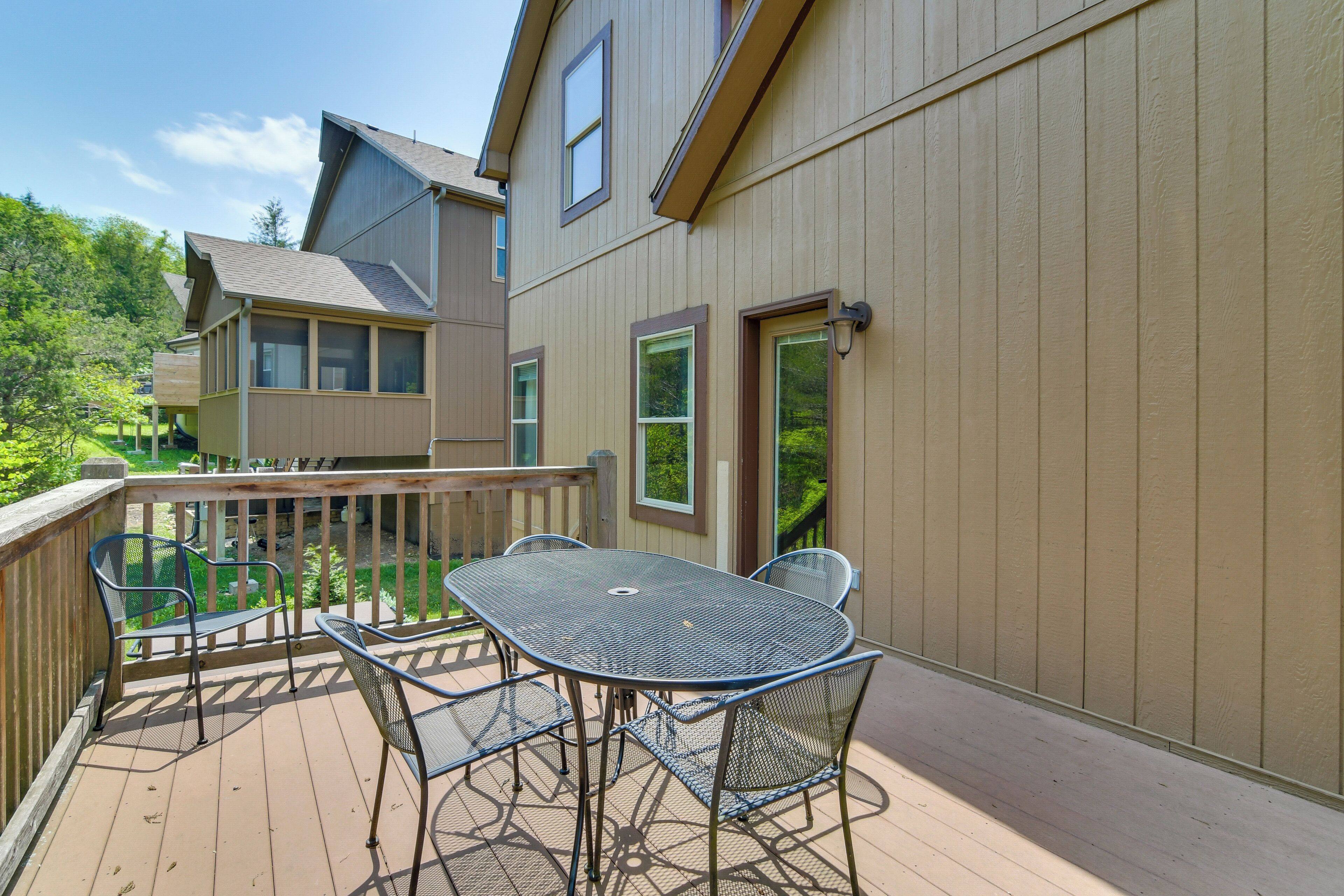 A deck with a table and chairs, overlooking a residential area.