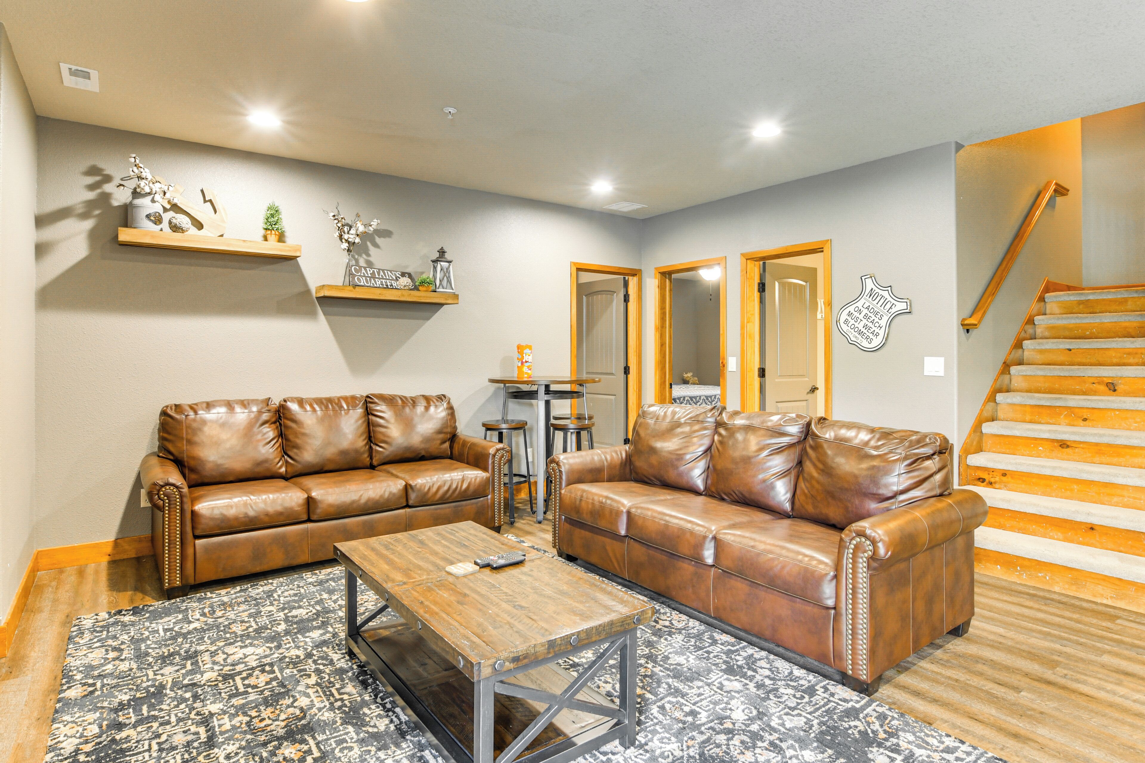 A living room with two brown leather sofas, a wooden coffee table, and patterned rugs.