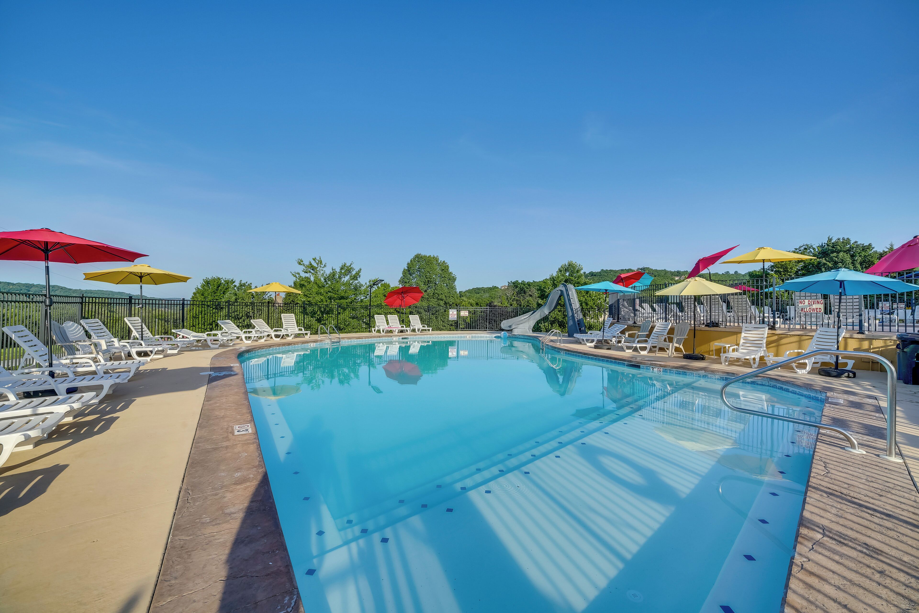 A swimming pool with lounge chairs and umbrellas.