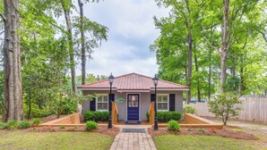 A house with a red roof, a blue door, and a brick pathway leading to the entrance. - Private Dock + Porch: Lakefront Retreat in Cobb! (Cobb)