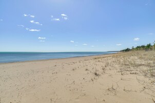 A beach with a clear sky and calm sea.