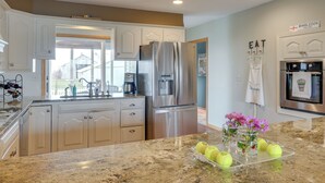 A modern kitchen with stainless steel appliances, a granite countertop, and a view of the outside. - Tennis Court & Deck: Pet-friendly Charles City Gem (Charles City)