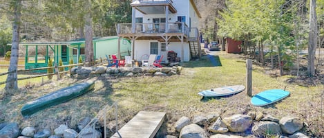A two-story house with a balcony, a dock, and a small boat.
