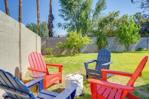 Relax in comfort with three Adirondack chairs surrounding a small table on the lush lawn.