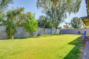 Enjoy a serene outdoor space surrounded by lush trees and shrubs, with seating areas and a beautifully manicured lawn.