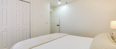 A bedroom with a bed, a ceiling fan, and a door.