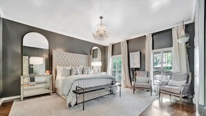 A spacious bedroom with a large bed, a bench, a chair, and a desk. - The Royale 2B 4B Luxury Garden Pool Yoga Room (Tampa)
