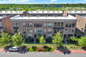 A multi-story brick building with a flat roof, multiple windows, and a central entrance.