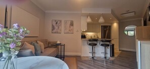 A modern apartment with a living area, kitchen, and dining space.