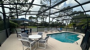 Un área de piscina al aire libre con una zona de estar cubierta y una piscina.