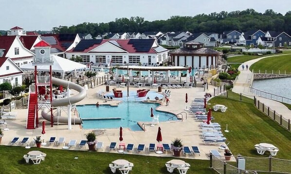 A resort with a large pool, a water slide, and a beach area with lounge chairs and umbrellas. - New Listing * 7 BR Coastal Club Resort Style Luxur (Lewes)