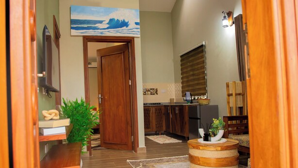 A modern kitchen with wooden cabinets, a built-in oven, and a window with blinds.