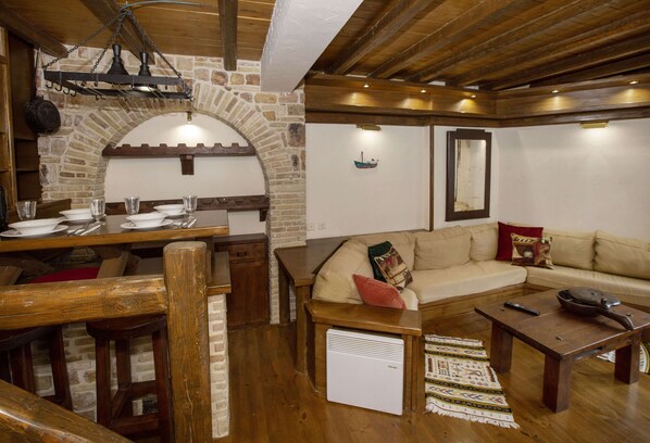 A rustic interior with a stone archway, wooden furniture, and a cozy seating area.