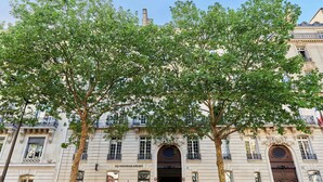 Un bâtiment à la façade classique, doté de fenêtres en arc de cercle et d’une enseigne indiquant « LES NOUVEAUX ATELIERS ».