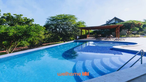 A swimming pool with a tiled deck, lounge chairs, and a covered seating area. - Apartamento em Gravatá com Lazer Completo (Gravatá)