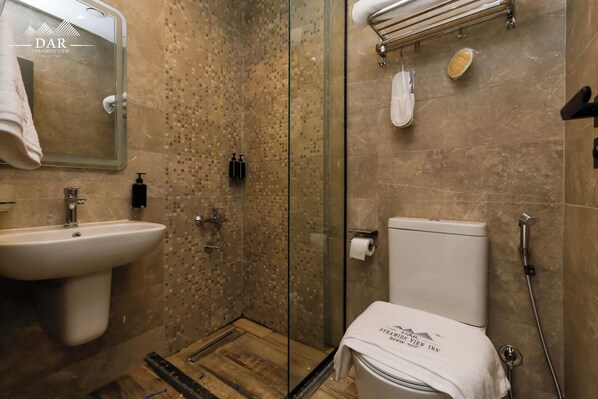 A bathroom with a glass shower enclosure, a sink, a toilet, and a towel rack. - Dar Pyramids View Inn RoofTop (Giza)