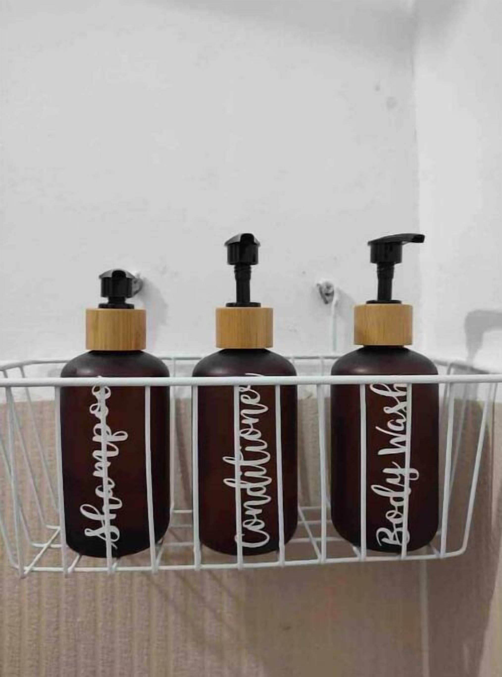 Three bottles of body wash in a white metal rack against a wall.