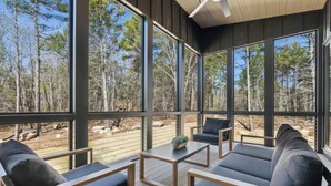 A modern outdoor seating area with a view of a forest.